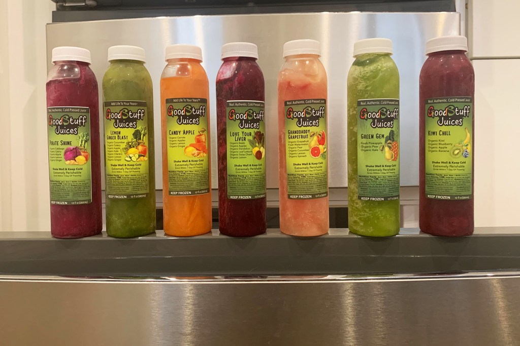 An array of juice bottles on a freezer door 